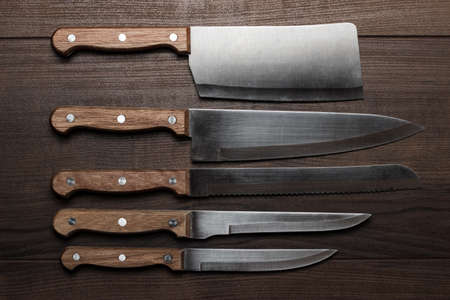 kitchen knifes over brown wooden tableの写真素材