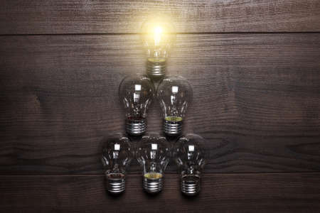 glowing bulb leadership concept on wooden backgroundの写真素材
