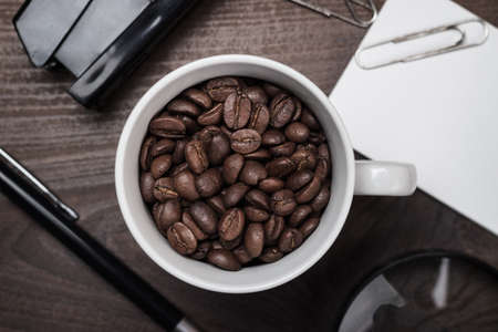 cup of coffee beans on wooden table in the office