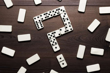 domino pieces forming question mark on wooden tableの写真素材