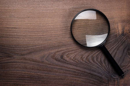 magnifying glass on wooden background