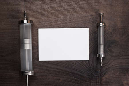 retro medical syringes and notebook on wooden backgroundの写真素材