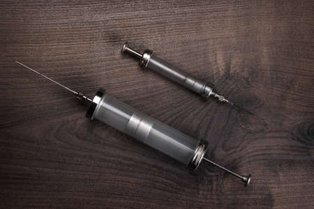 retro medical syringes on wooden backgroundの写真素材