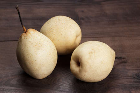 three fresh pears on wooden tableの写真素材