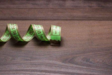 green measuring tape on wooden backgroundの写真素材