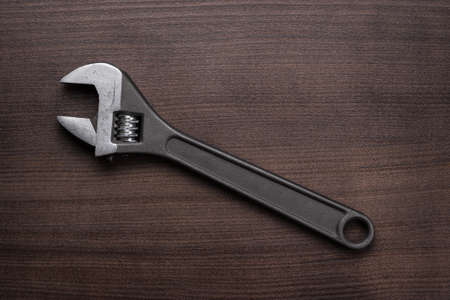adjustable wrench on the brown wooden tableの写真素材