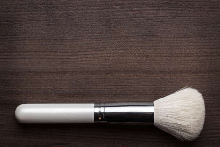 white make-up brush on brown wooden tableの写真素材