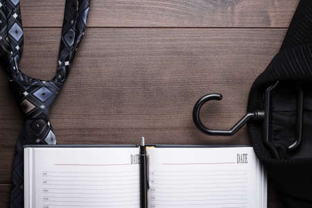 opened notebook on the table with suit and tieの写真素材