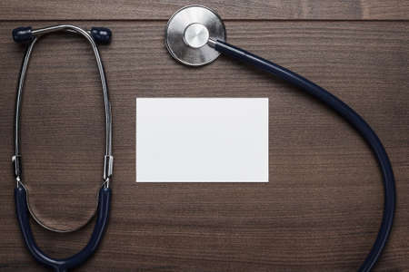 statoscope and blank notebook over brown wooden tableの写真素材