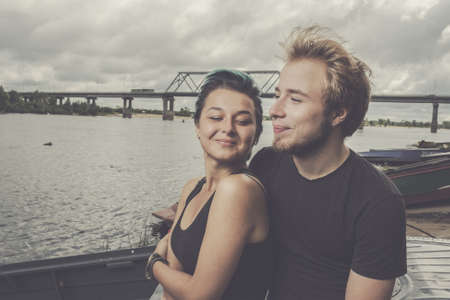 young happy loving couple on the river bankの写真素材