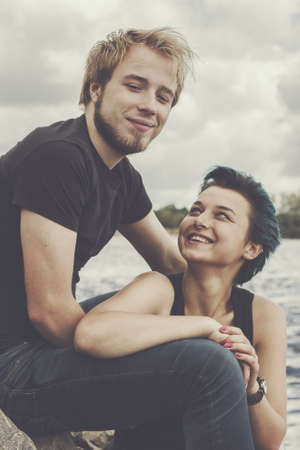young happy loving couple on the river bankの写真素材