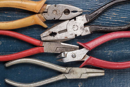 different pliers on the blue wooden background