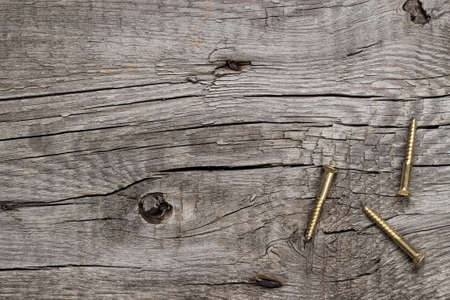 new yellow screws on the wooden table background
