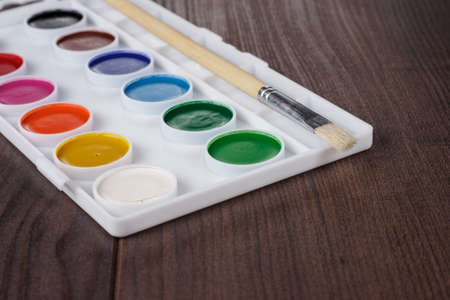 palette with paint and brush on the wooden tableの写真素材