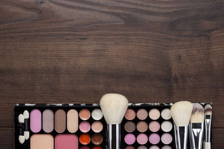white make-up brushes on brown wooden background