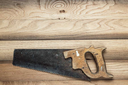 old rusty saw on the wooden backgroundの写真素材