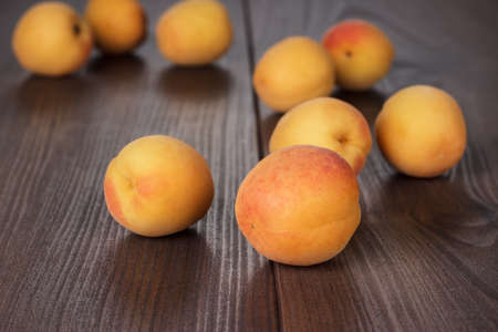 some fresh apricots over brown wooden の写真素材