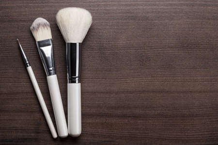 white make-up brushes on brown wooden の写真素材