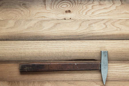 old hammer on the brown wooden background