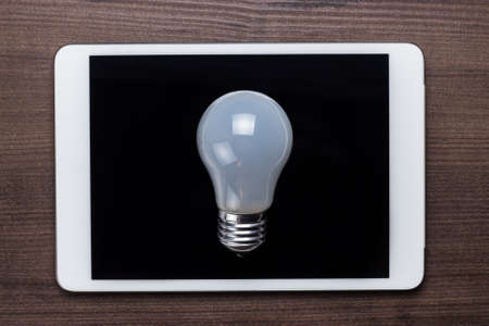 white bulb on the tablet computer conceptの写真素材