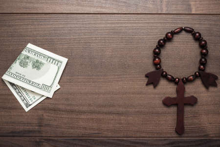 wooden cross and money on brown table background conceptの写真素材