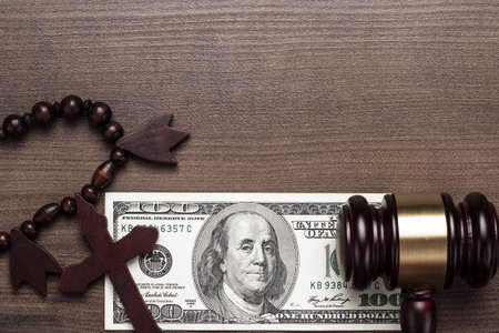 wooden cross gavel and money on brown table background conceptの写真素材