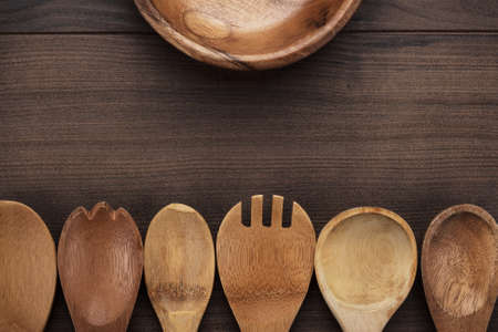 different wooden spoons and bowl on the blue tableの写真素材