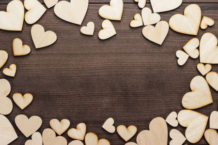 wooden heart shapes on the brown tableの写真素材