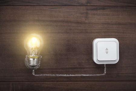 glowing bulb uniqueness concept on brown wooden backgroundの写真素材