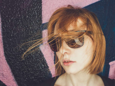 stylish portrait of a casual young woman with sunglasses dancing
