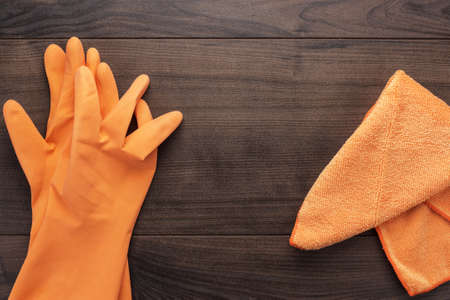 orange rubber cleaning gloves on wooden backgroundの写真素材