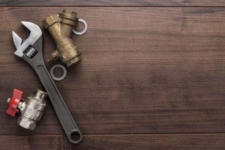adjustable wrench and pipes on the wooden backgroundの写真素材