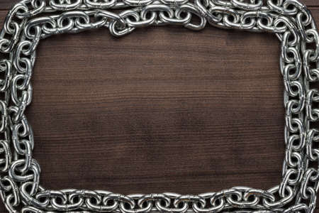 chain frame on the brown wooden backgroundの写真素材