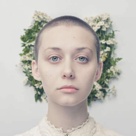 portrait of beautiful bald-headed girl over floral backgroundの写真素材