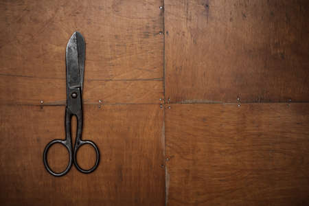 old black scissors on the wooden backgroundの写真素材