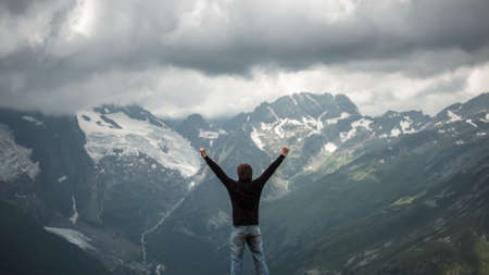 happy traveller on the top of mountain stormy landscapeの写真素材