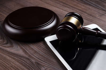 judge gavel and tablet computer on the tableの写真素材