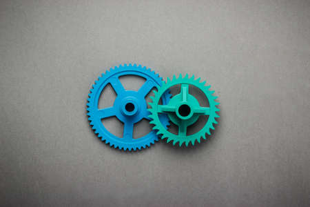 blue and green gears on the grey backgroundの写真素材