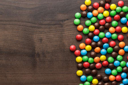 colorful sweets on the brown wooden table backgroundの写真素材