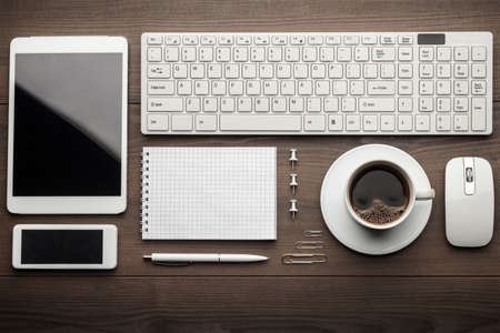 overhead of essential office objects in order on wooden deskの写真素材