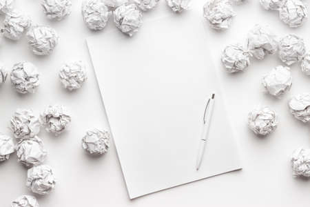 blank sheet of paper on the white table with a pen