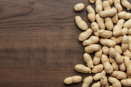 many roasted peanuts on the wooden table backgroundの写真素材