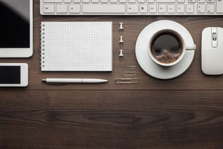 overhead of essential office objects in order on wooden desk with copy spaceの写真素材