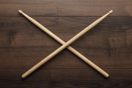pair of wooden drumsticks crossed on wooden tableの写真素材