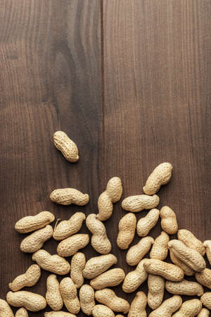 many roasted peanuts on the wooden table backgroundの写真素材