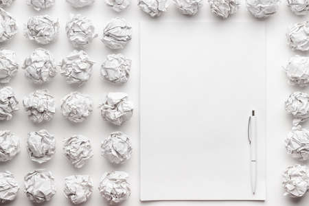 blank sheet of paper on the white table with a pen creative process conceptの写真素材