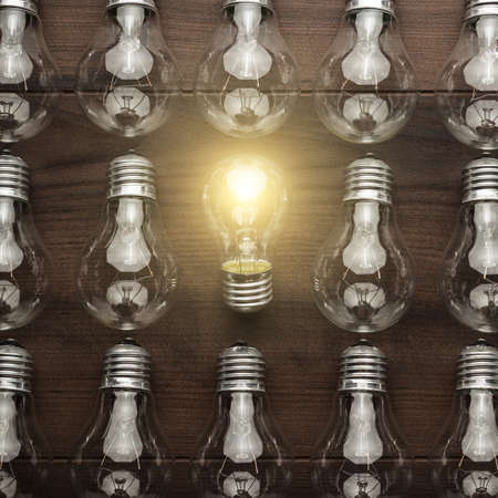 glowing bulb uniqueness concept on brown wooden table