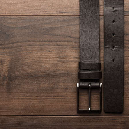 brown leather belt for men on wooden tableの写真素材