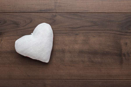 knitted plush heart shape on the wooden tableの写真素材