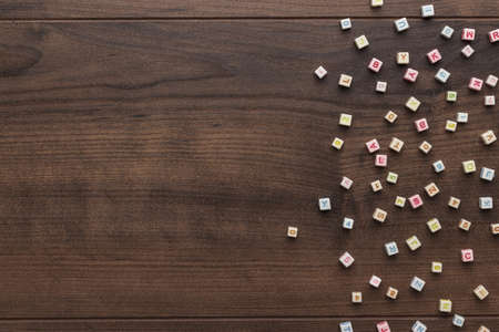 different colorful beads on the brown wooden table with copy space